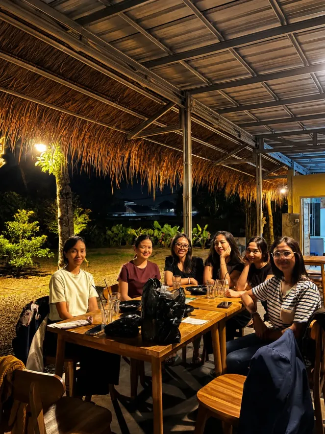 Guests seated under the thatched roof at night