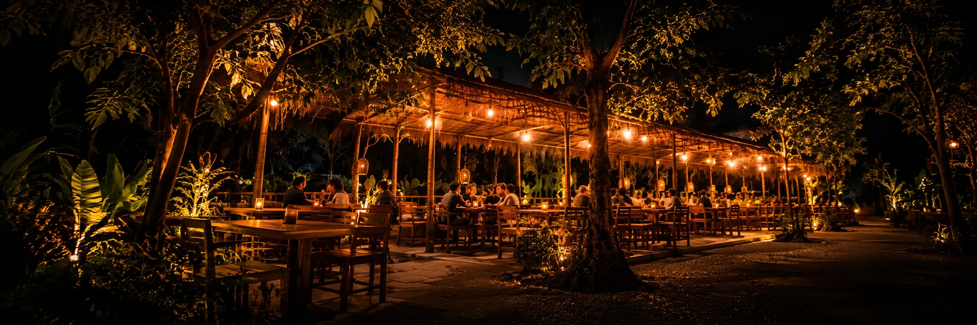 A wide night view of guests seated under the lights at Tegalan Spirit
